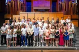 Gruppenfoto der Absolventinnen und Absolventen bei RUB Finish 2026 auf der Bühne des Audimax der RUB